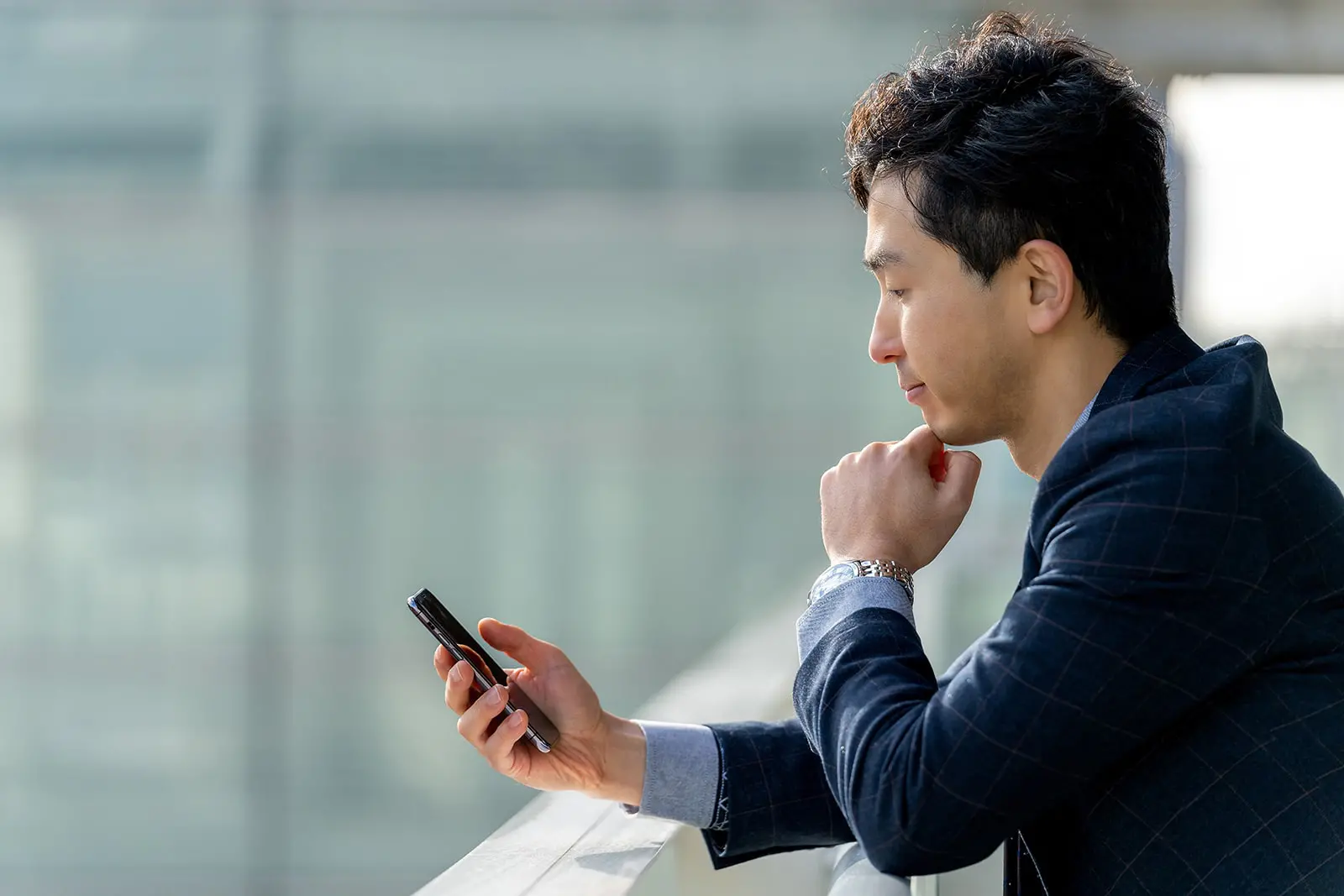 スマホを眺めている男性の画像